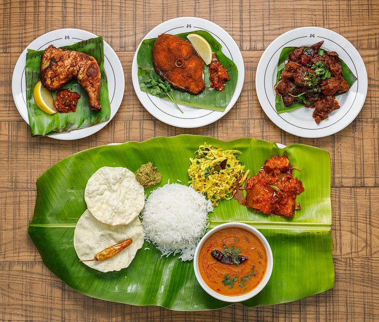 some tamil vegetarian rice and curries served on a large banana leaf