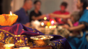 a happy family celebrating Diwali, with the image focused on the lamps on the table